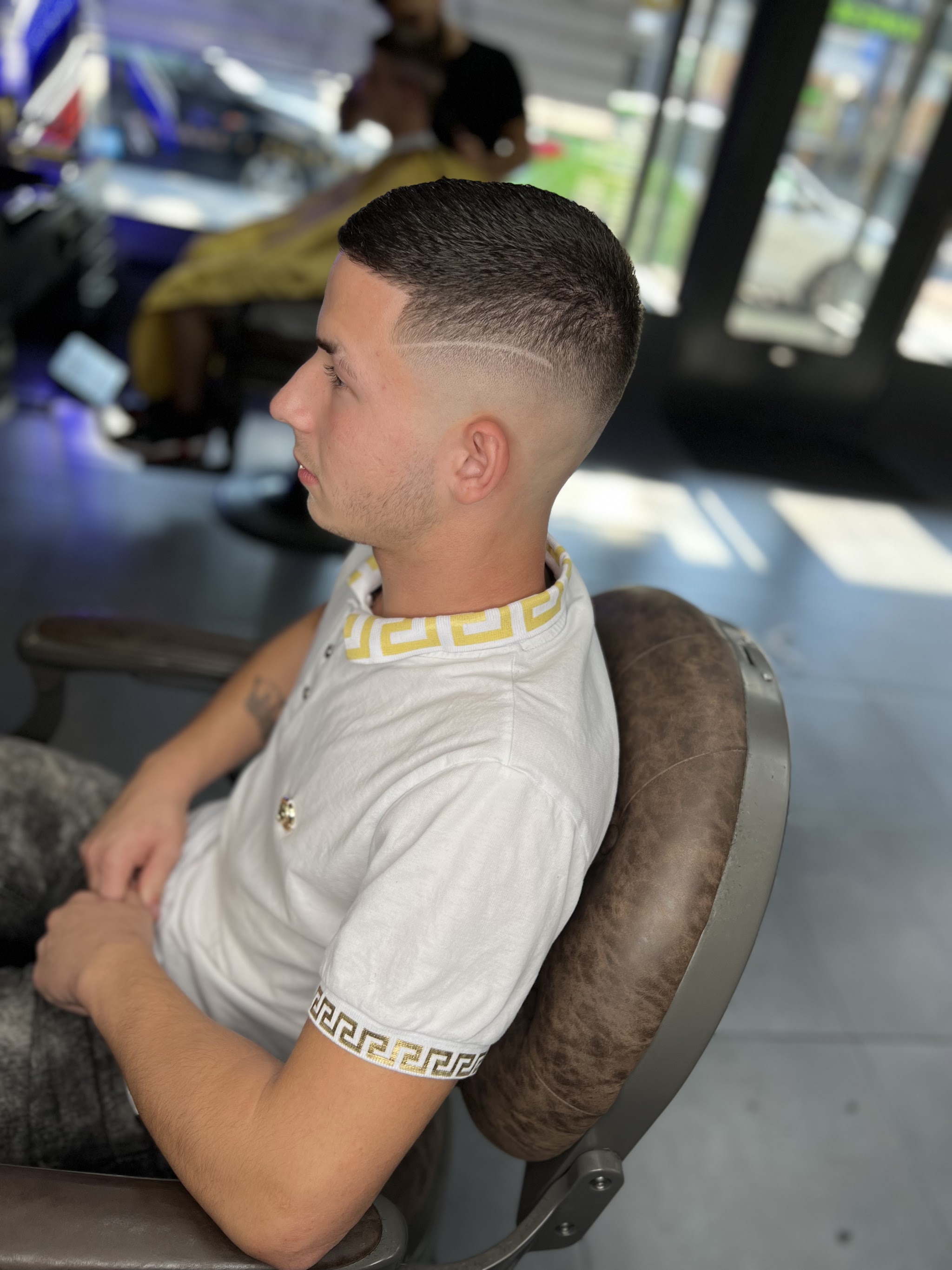 Klant in de kappersstoel met een skin fade, van opzij