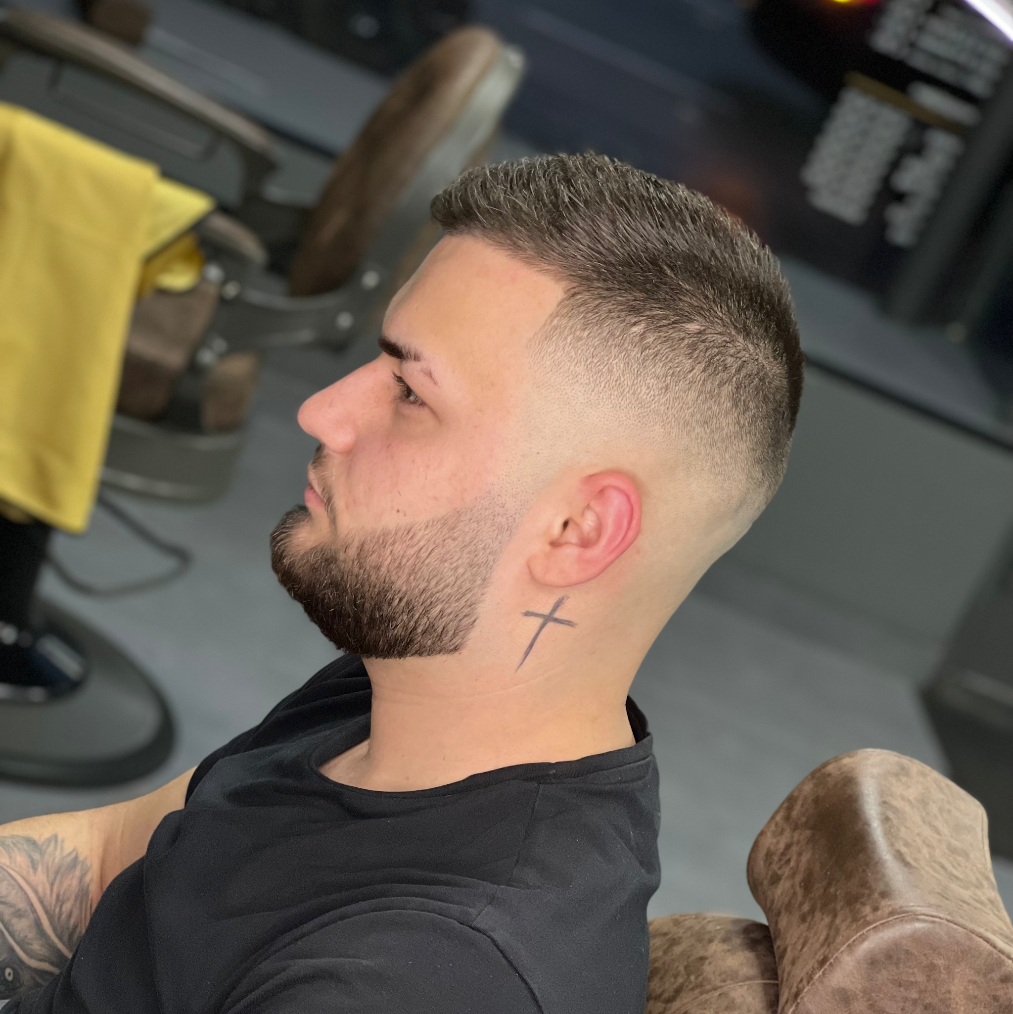 Close-up van een fade met kort getrimde baard, van opzij